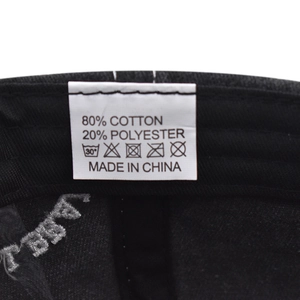 Detail of internal care label on washed cotton baseball cap with fabric composition