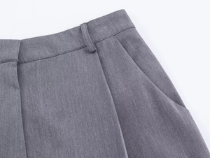 Gros plan détaillé du pantalon gris montrant la texture sergé et la couture de taille