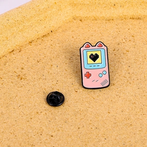 Pink retro handheld game console enamel pin with cat ears and pixel heart design
