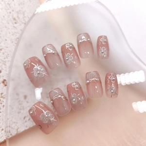 Handmade cat-eye press-on nails with pink gradient, silver flowers, and white pearls