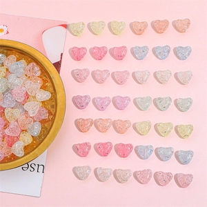 Colorful heart-shaped crackle glass beads in a gold dish for DIY jewelry making