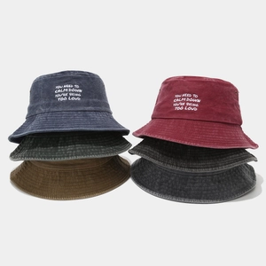 Five assorted vintage washed cotton bucket hats with embroidered text on a gray background