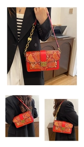 Detailed view of red snakeskin crossbody bag with gold chain strap and metal clasp