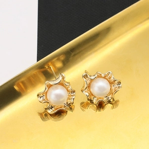 Macro shot of 18k gold plated petal earrings featuring round white freshwater pearls