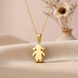Detail of gold girl pendant on O-chain against champagne silk and dried flowers