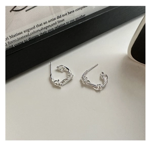 Macro detail of S925 sterling silver twisted knot hoop earrings with a polished finish