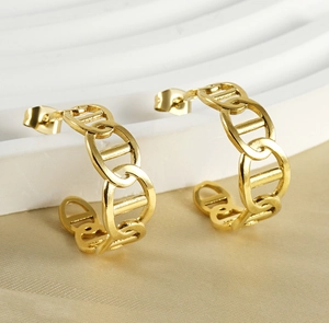 Detail view of 18K gold plated C-shaped chain link earrings on champagne silk background