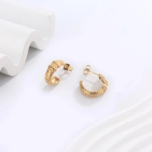 Macro shot of 18K gold plated U-shaped earrings with intricate diamond-grid texture detail