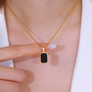 Detail of a square black shell pendant on a gold titanium steel necklace for women