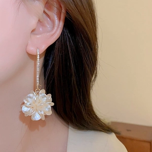 Detail of long floral earrings with iridescent petals and sparkling crystal studs