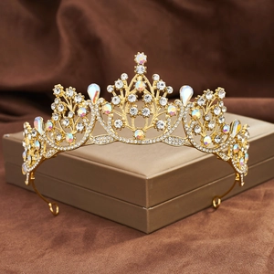 Detail view of a golden Baroque crown with teardrop rhinestones on a textured brown fabric