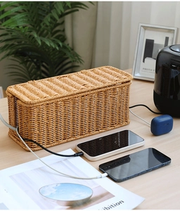 Detail of faux rattan cable management box on a desk showing woven texture and interior capacity