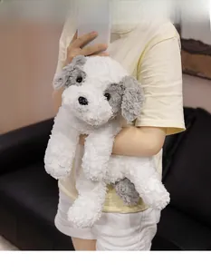 Close-up of a cute plush puppy toy in white and grey colors held by a person