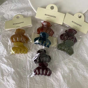 Assorted mini jelly hair claws in neutral colors on card packaging for side fringe