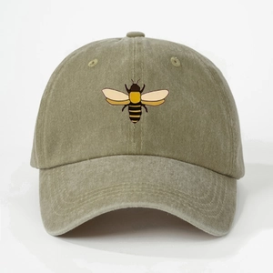 Detail of an olive green washed cotton baseball cap with a printed bee motif on front