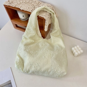 Detail der Blumenstickerei auf hellgrüner Chiffon-Tasche im gemütlichen Cream-Stil