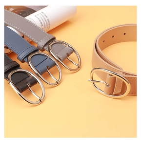 Detail of four PU leather belts in khaki, gray, blue, and black with oval metal buckles