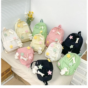 Flat lay of colorful school backpacks with cute bear charms in five soft pastel colors