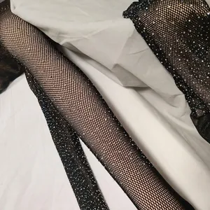 Close-up of black fishnet stockings with sparkling silver rhinestones on elastic fabric