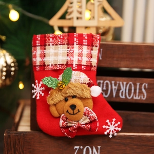 Close-up of a red Christmas stocking with a plush bear, sequins and festive snowflake details