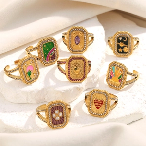 Détail de bagues vintage plaquées or 18K avec motifs en émail et petits cristaux