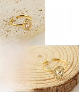Detail of 18K gold plated stainless steel ring featuring a teardrop zircon and small crystals