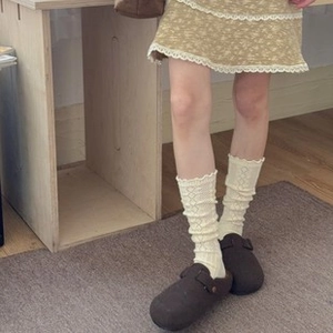 Détail de chaussettes en laine crème à dentelle portées avec des souliers marron