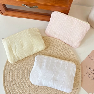Detailed view of textured striped makeup bags with hollow lace trim and zippers