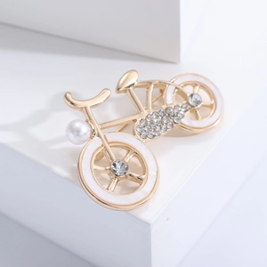 Macro shot of bicycle brooch featuring sparkling rhinestones, gold plating and pearl details