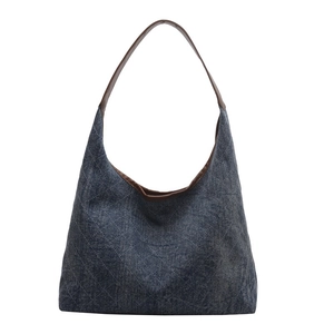 Denim tote bag with brown leather straps and diamond quilted pattern on white background