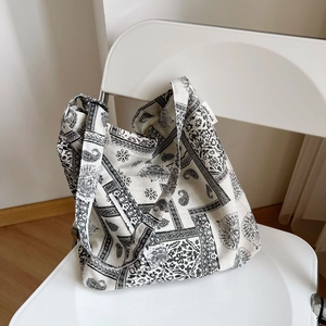 Retro paisley canvas tote bag with black and white patterns on a white chair