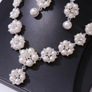 Elegant bridal pearl jewelry set with flower pattern necklace and matching earrings
