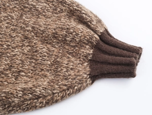 Close-up of ribbed brown cuffs and thick cable knit texture on a vintage wool cardigan
