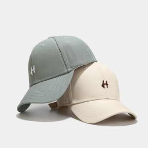 Dettaglio del cappellino da baseball con ricamo della lettera H e cuciture a sei file