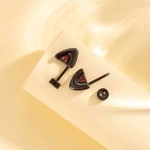 Triangle titanium steel stud earrings with red zircon stones on a beige pedestal