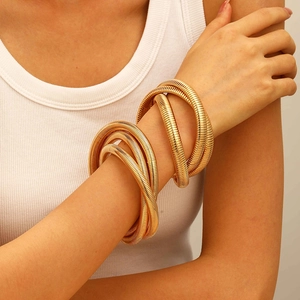 Exaggerated wide gold spring coiled snake bracelet in spiral geometric metal design