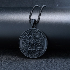 Detail of black stainless steel Saint Michael pendant with embossed religious motif