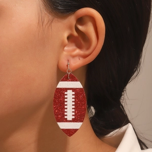 Close-up of sparkling red sequin football earrings worn by a model in a lifestyle setting