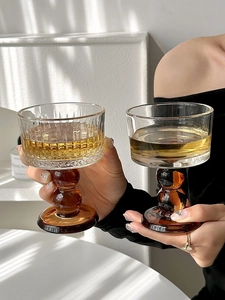 Detail of vintage glass goblets with amber ball stems in ribbed and smooth textures
