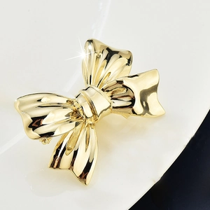 Elegant gold bow brooch in metallic minimalist design for women fashion accessories