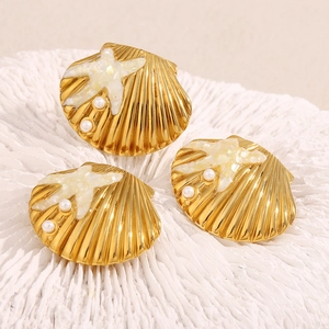 Detail of 18K gold plated starfish shell earrings with pearl inlay on coral background