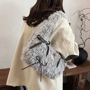 Grey plush shoulder bag with brown bows shown on model for chic autumn winter style