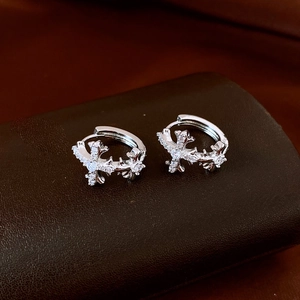 Macro view of silver drop earrings with cross design and sparkling cubic zirconia stones