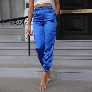 Detail of electric blue satin cargo pants with high waist and side pockets on model