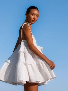 Detail of white tiered ruffle sundress with backless design and thin shoulder straps