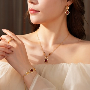 Detaillierte Nahaufnahme von Vintage-Goldschmuck-Set mit roten Zirkonia am Modell