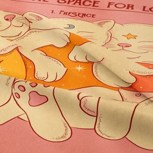 Detailed close-up of woven fabric showing cartoon cat moon print and textile texture