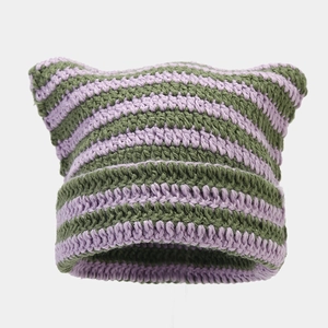 Detail of handmade knit cat ear beanie with purple and olive green striped texture
