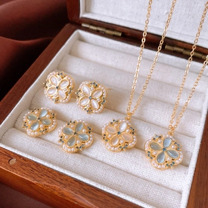 Detail of flower jewelry set with pearl, blue zircon, and shell inlay on velvet