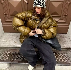 Outdoor street style view of padded puffer jacket in glossy bronze finish with high neck